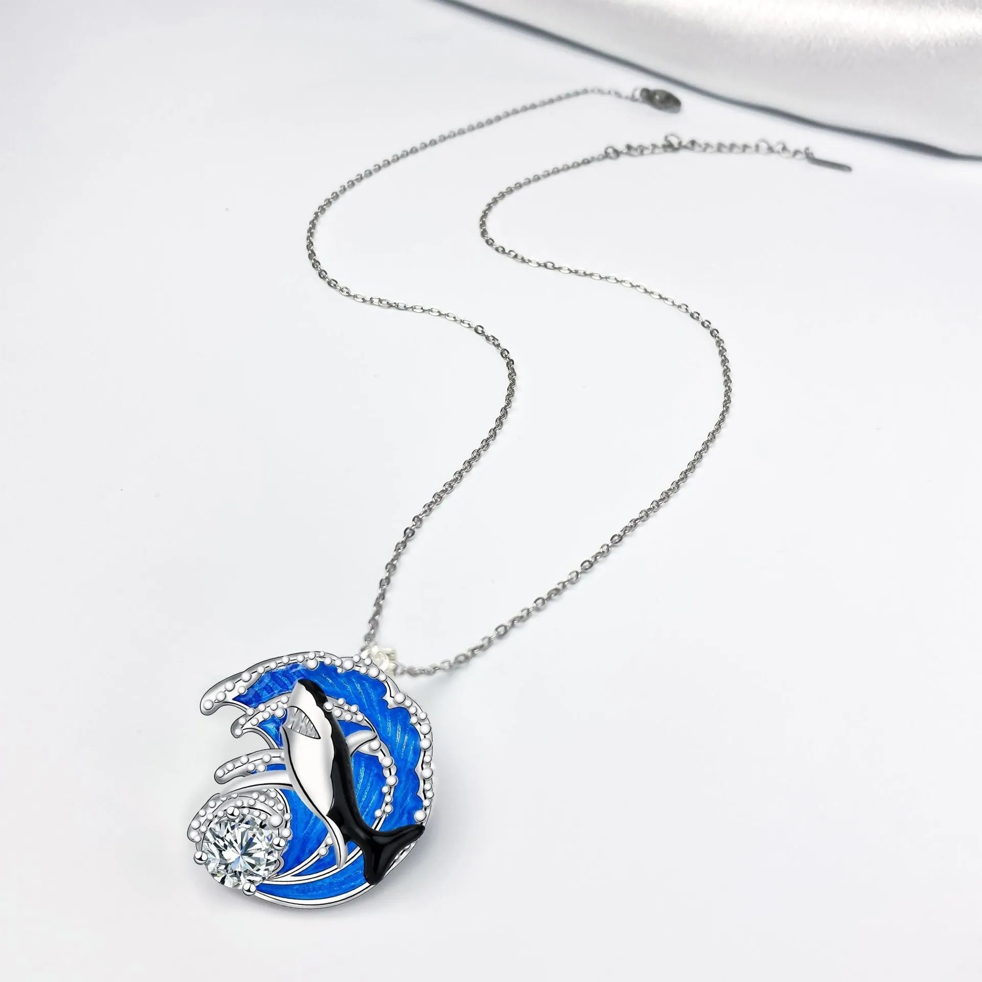 Women's silver-tone necklace with a detailed shark pendant on a cross chain.