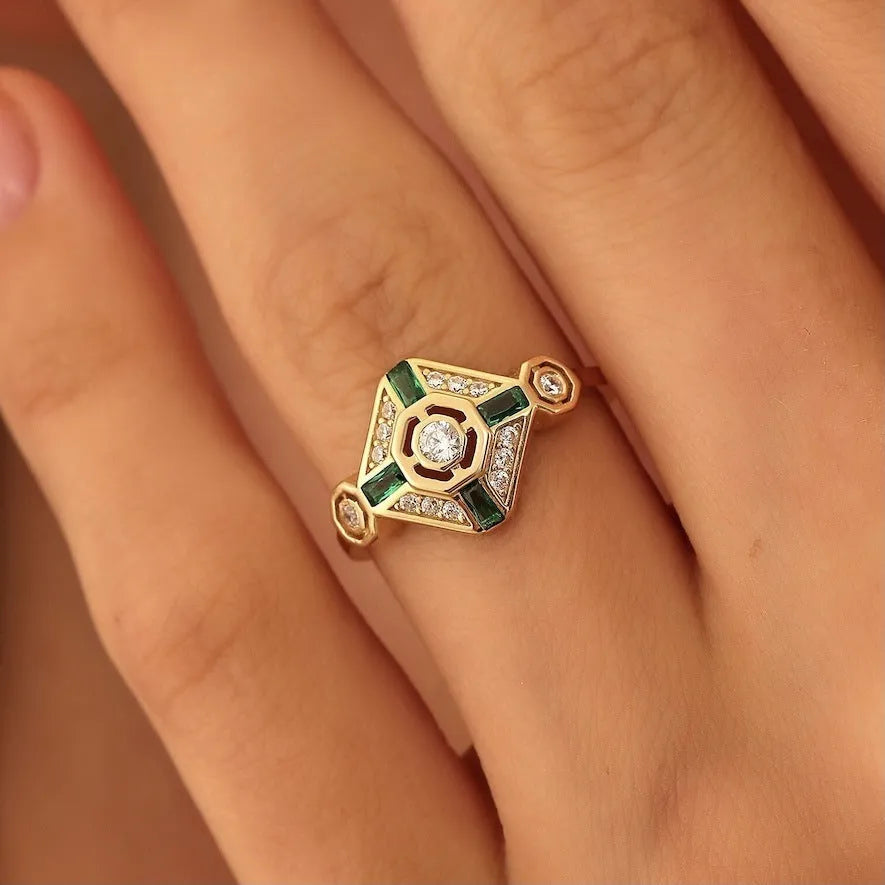 Square geometric women's ring with green diamond colour on a hand.