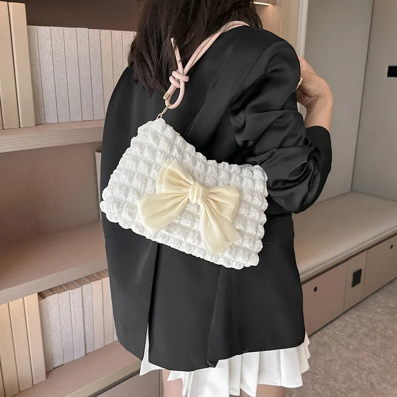 Women's one-shoulder canvas handbag in horizontal square shape with single strap.