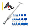 Metal automotive dent repair tool with blue adhesive pieces and T-shaped hammer on a car panel surface