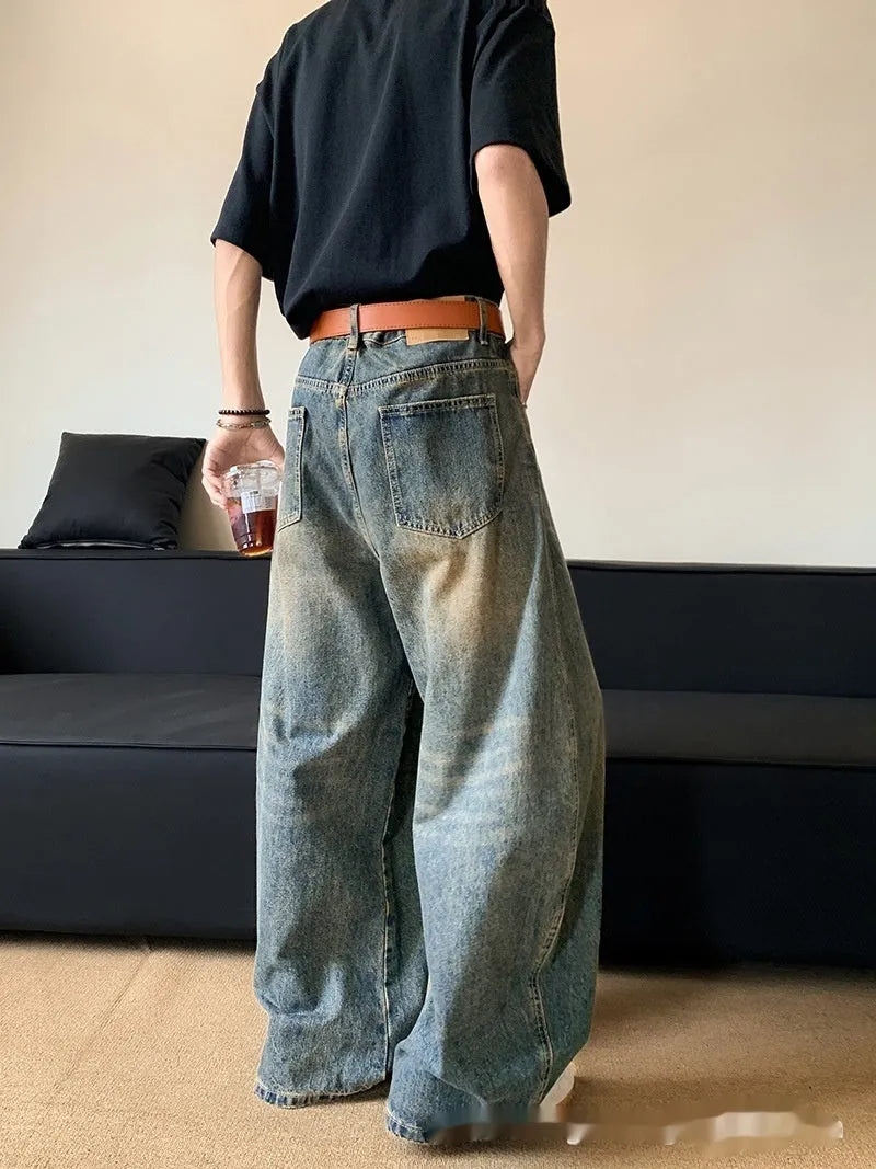 Men's retro blue distressed wide-leg jeans with a slimming fit through hips and thighs.