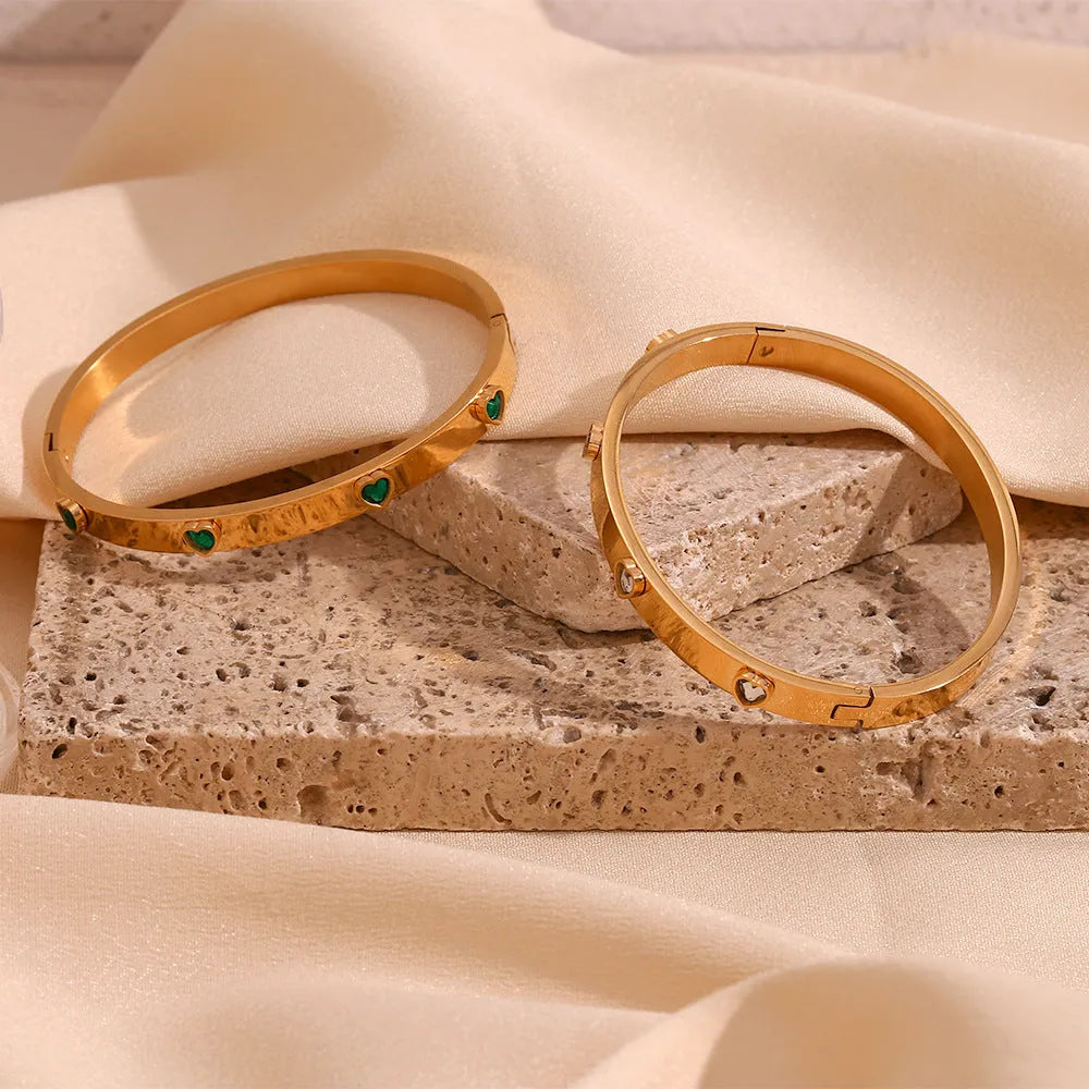 Golden electroplated stainless steel bracelet with a micro-inlaid peach heart charm for women.