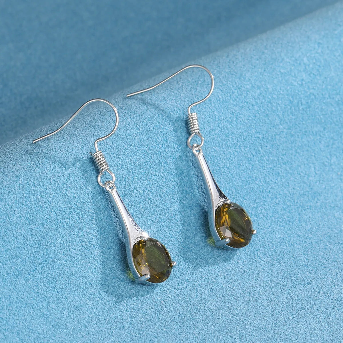 Olive green drop-shaped alloy earrings with posts on a white background.