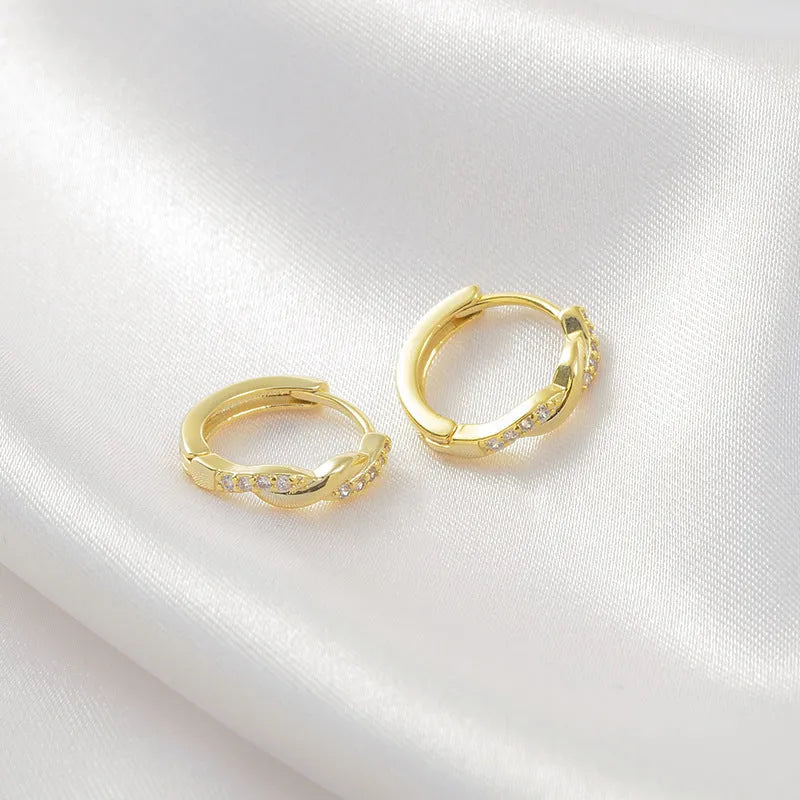 Women's geometric round earrings with interwoven hemp rope detail on a diamond-cut copper frame in gold colour.
