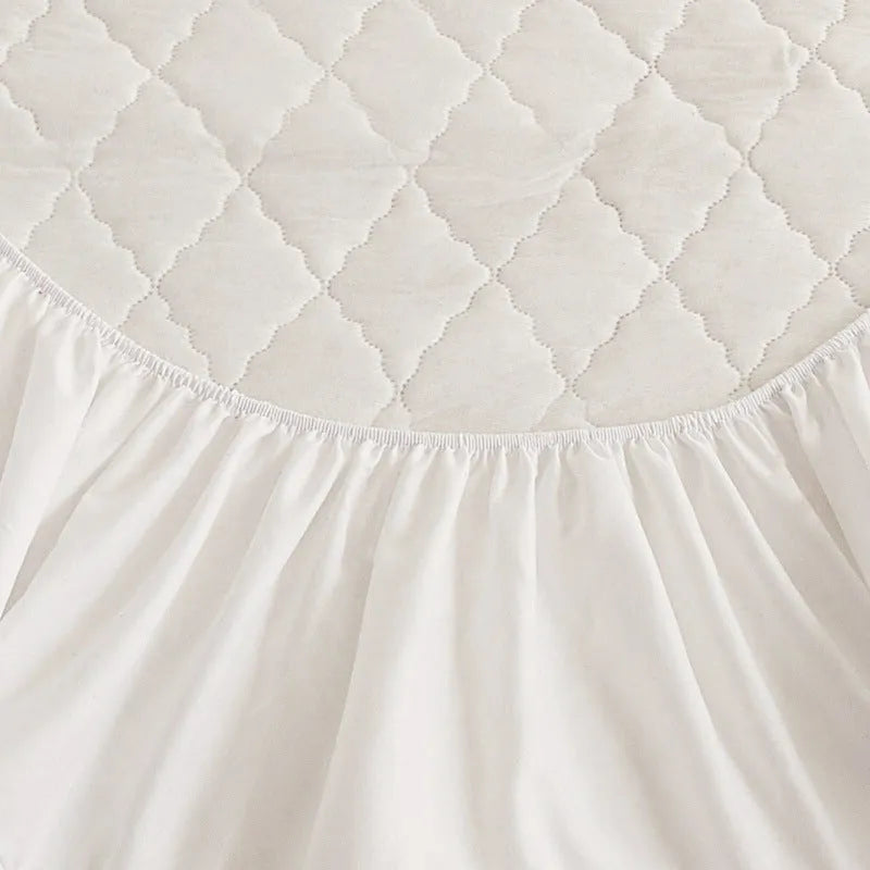 Diamond lattice quilted waterproof mattress protector in bamboo fibre, shown in a solid colour on a bed.