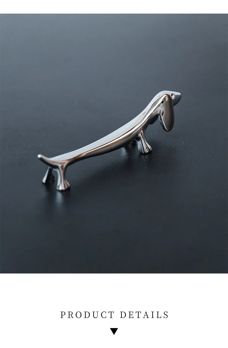 Silver zinc alloy sausage dog chopstick rest knife holder on desk with pen and chopsticks
