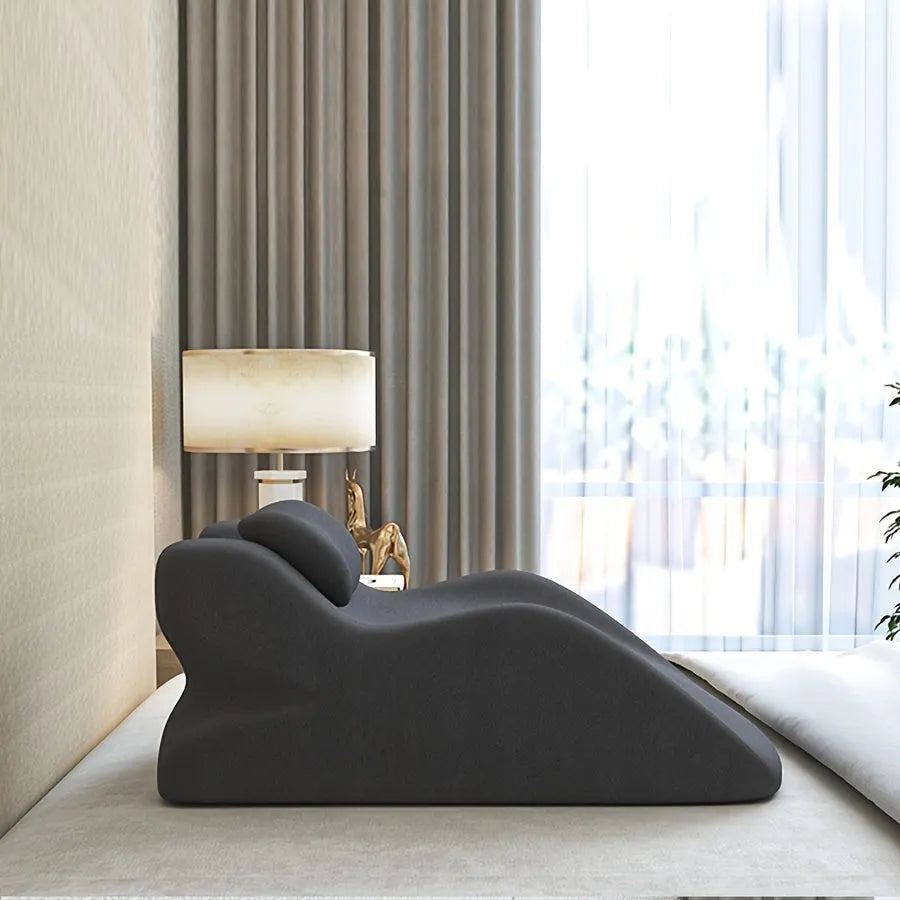 A stomach sleeper pillow shown in light grey, designed for prone positions and reading in bed.