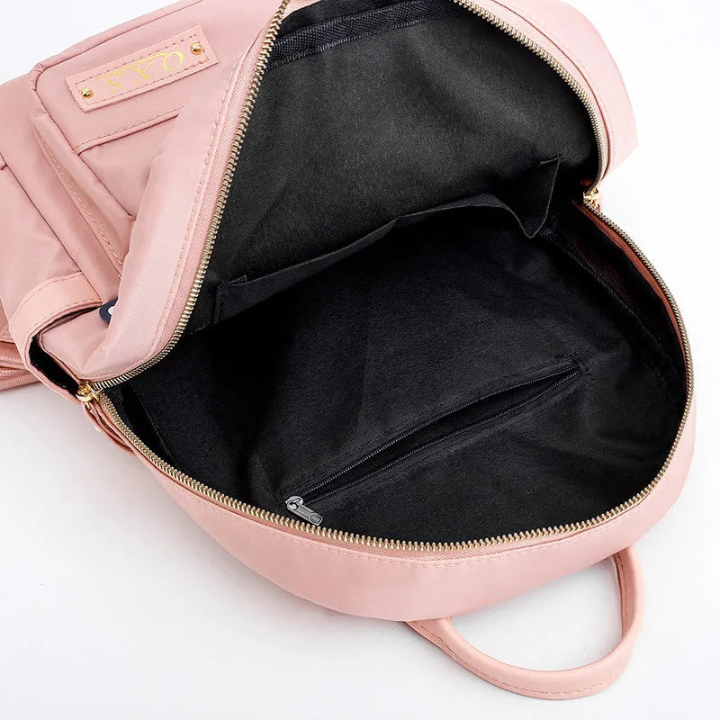 Black women's casual nylon backpack with soft handle and shoulder straps showing internal compartments