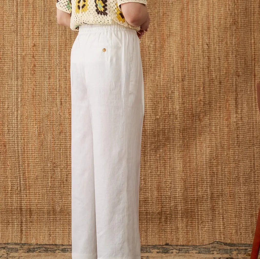 Straight-leg linen trousers in greige colour with a high elasticated waistband on a hanger.