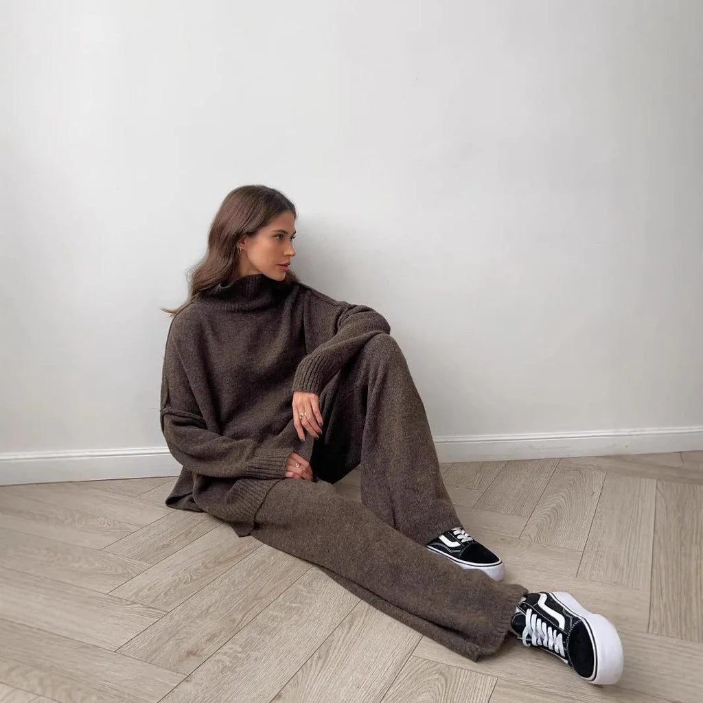 Women's dark grey acrylic knitted sweater with side slits and matching trousers.
