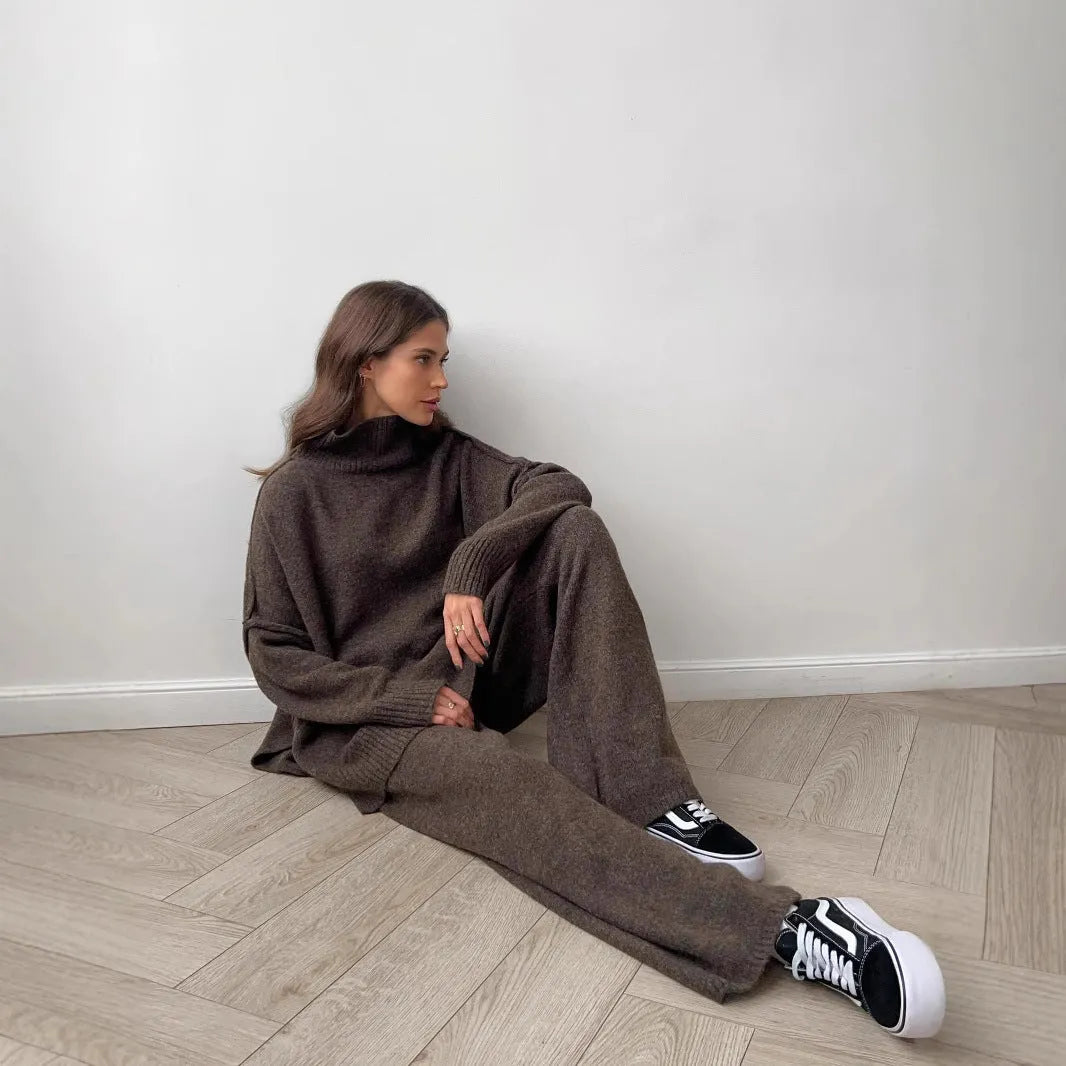 Women's dark grey acrylic knitted sweater with side slits and matching trousers.