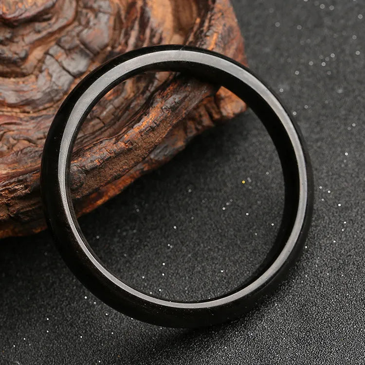 Black obsidian geometric ethnic bracelet with natural silver stone cat's eye design on a wrist.