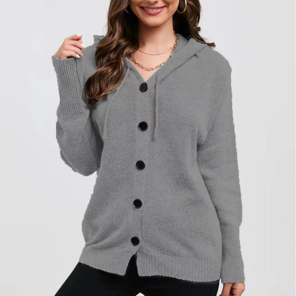 Woman wearing a thick, loose-fit hooded cardigan sweater in a solid colour.