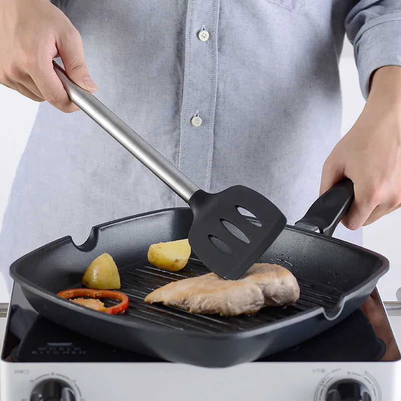Black silicone kitchen utensil set of 16 pieces including spatulas and spoons on a countertop