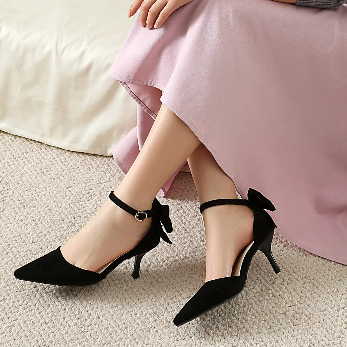 Women's pointed toe suede stiletto high heels with bowknot detail in black, pink, and beige