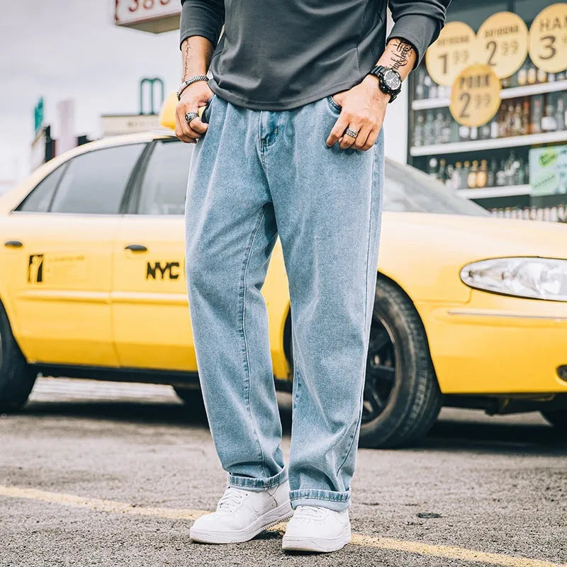 Men's loose straight fit casual jeans in dark blue cotton fabric, showing mid waist and zipper fly.