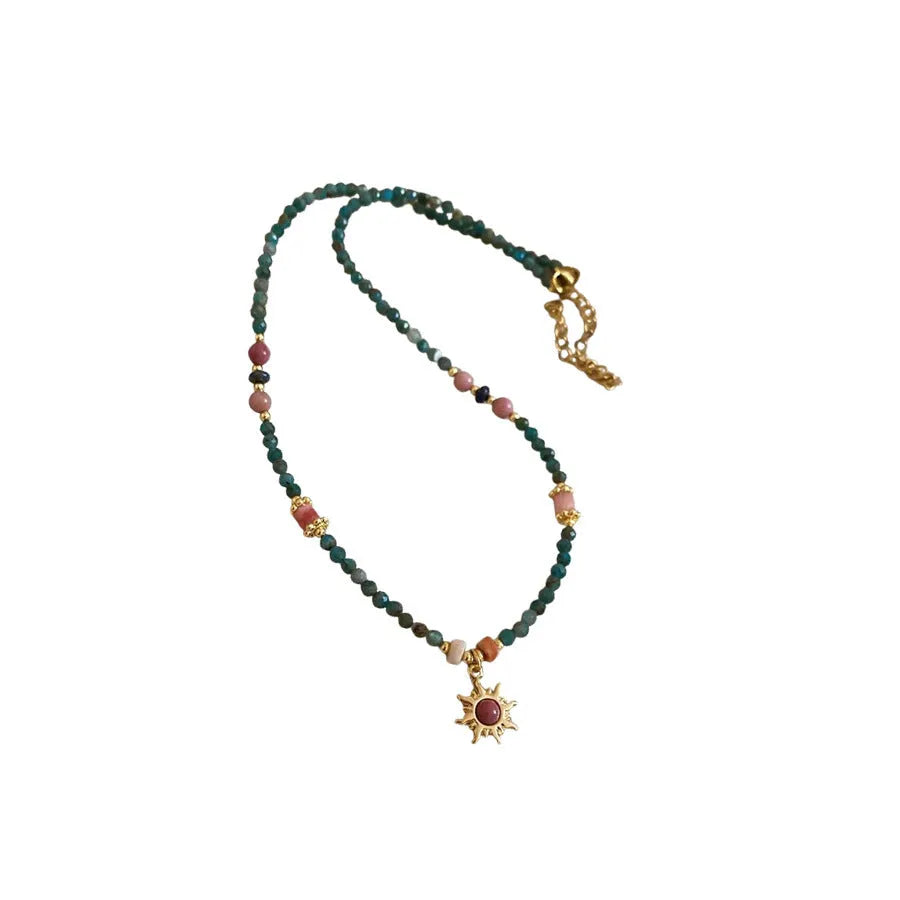 Freshwater pearl necklace with sun motif stone pendant on an adjustable clavicle chain.