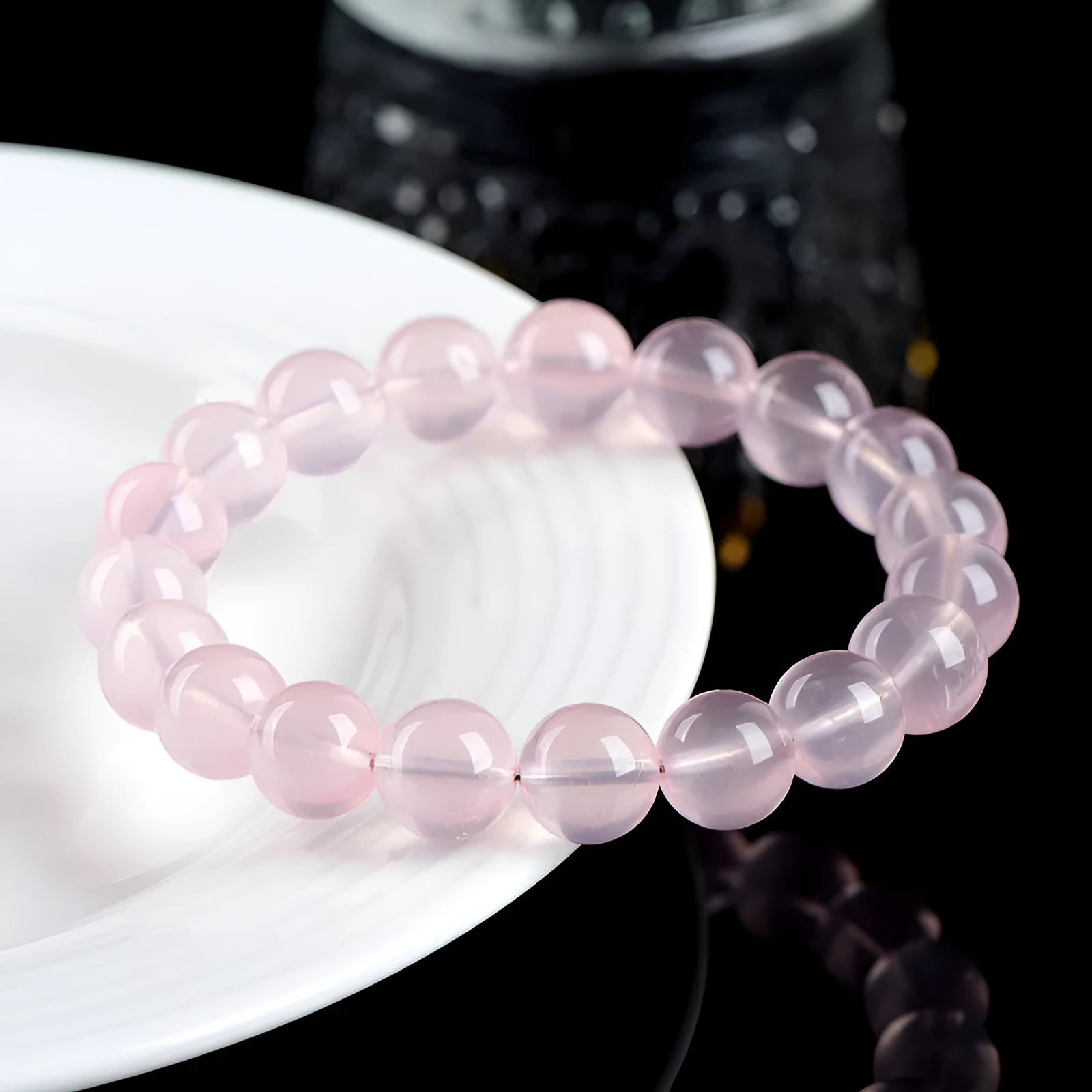 Women's natural starlight crystal round bead bracelet in pink on a white background.