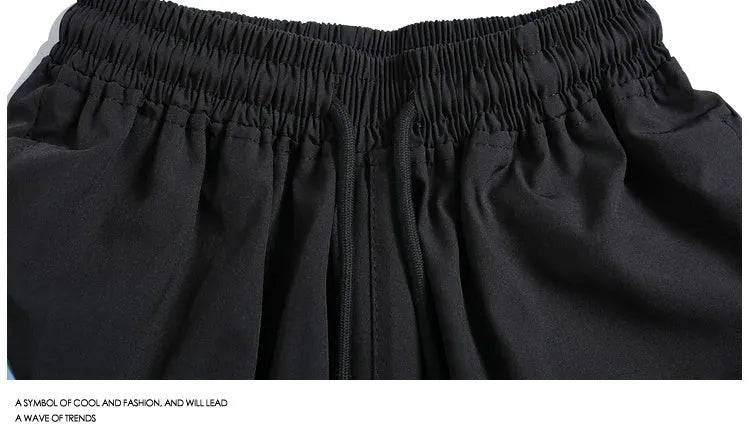 Men's black quick-drying sports shorts with elastic waistband in loose straight-leg cut above knee length
