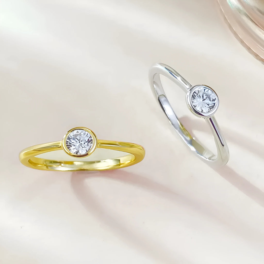 Minimalist crown-shaped silver ring with line detailing on a white background.