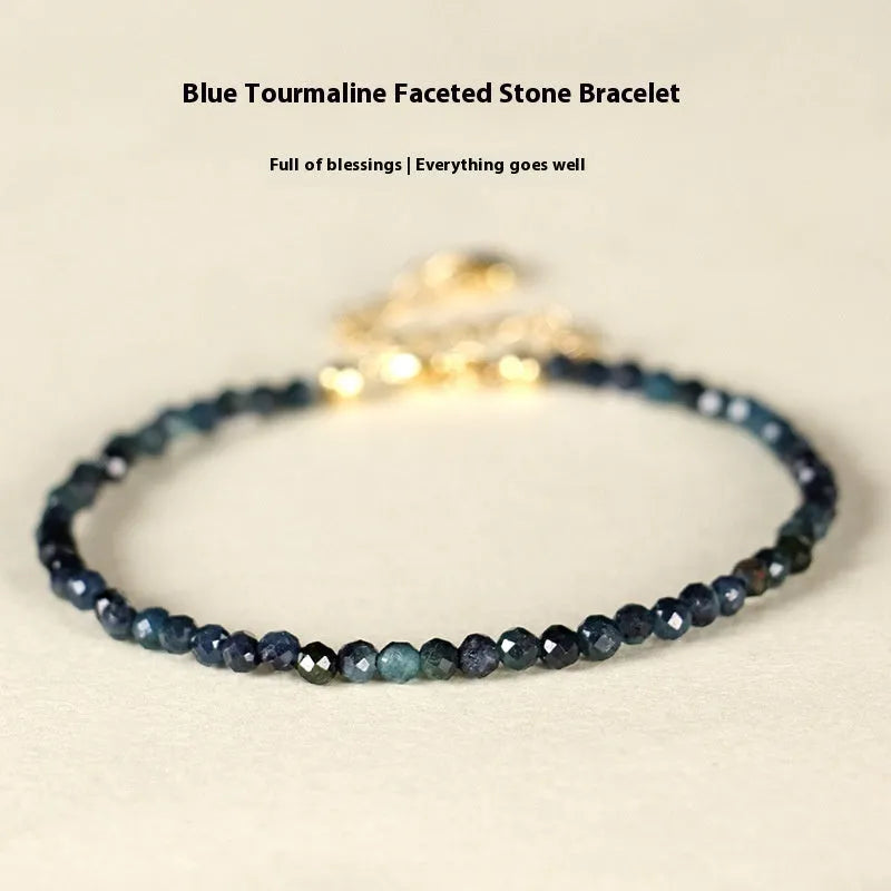 Close-up of a blue tourmaline bracelet with 3mm cut beads and spacer beads.