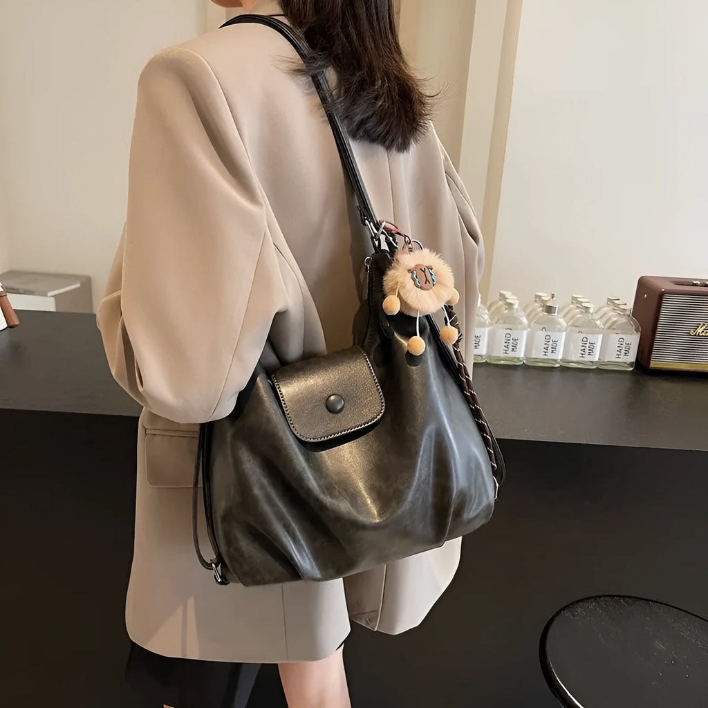 Black PU leather women's single strap shoulder bag showing horizontal square shape and internal mobile phone compartment