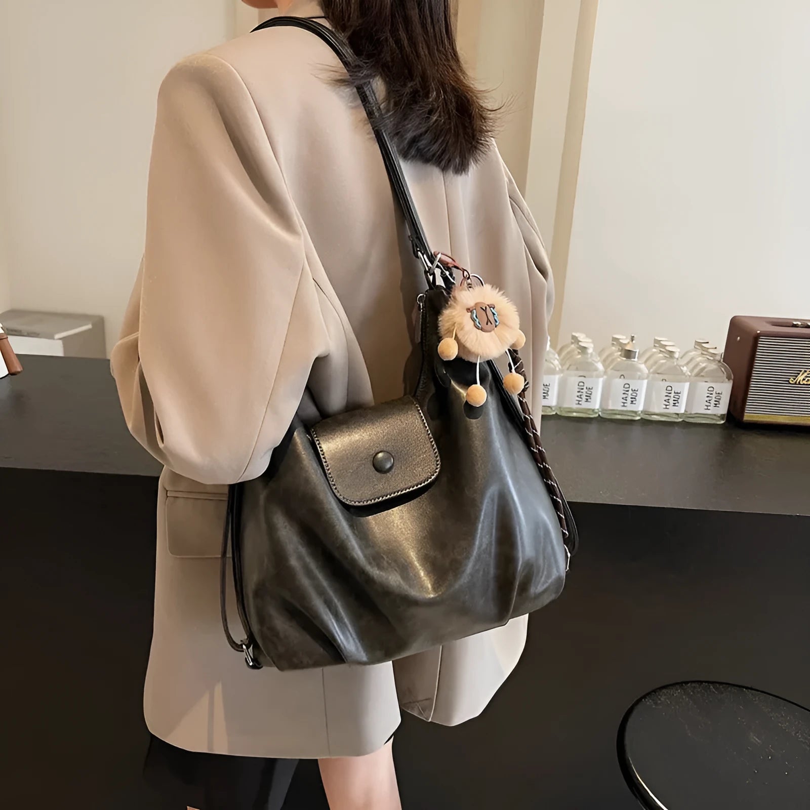 Black PU leather women's single strap shoulder bag showing horizontal square shape and internal mobile phone compartment