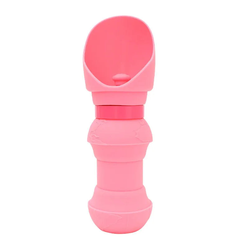 A collapsed flat and an opened pink silicone folding pet water cup on a grey background.