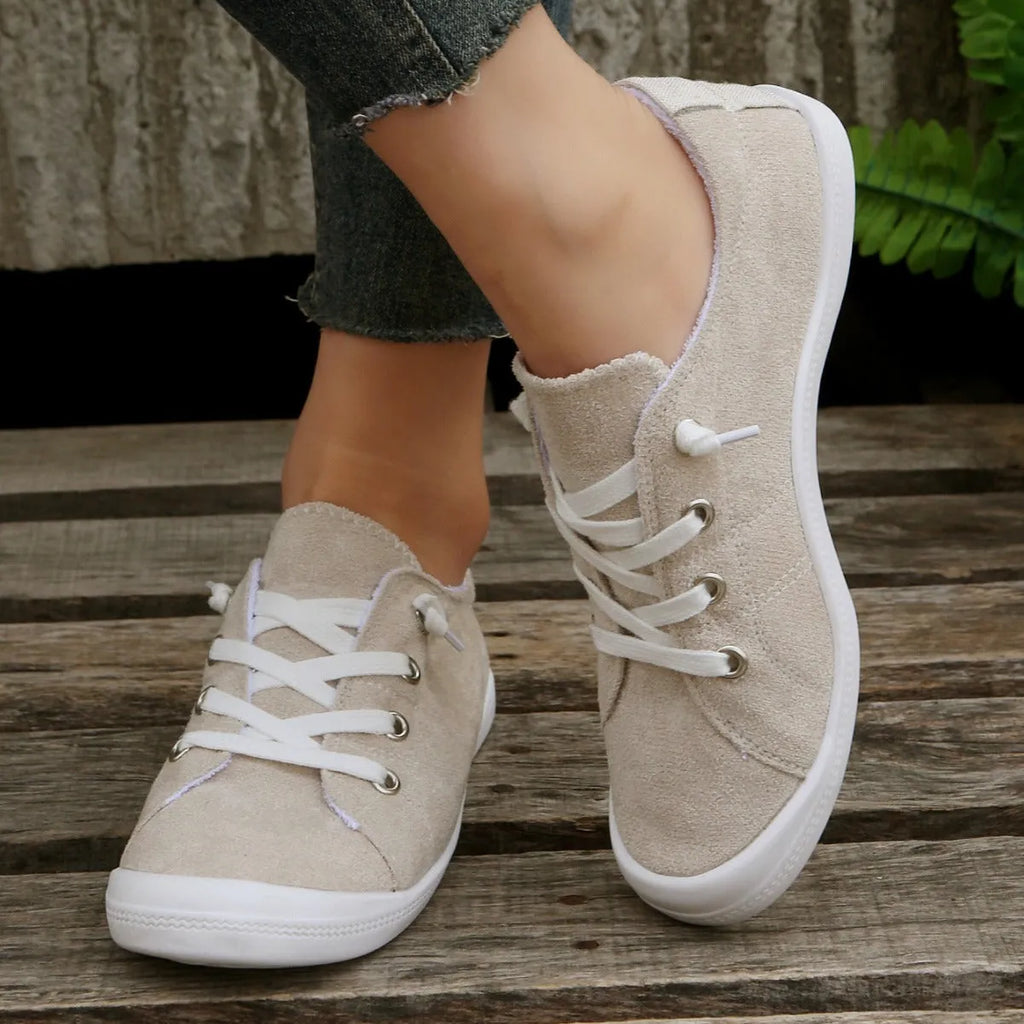 Women's creamy white casual low-top sneaker with soft fabric upper and rubber sole.