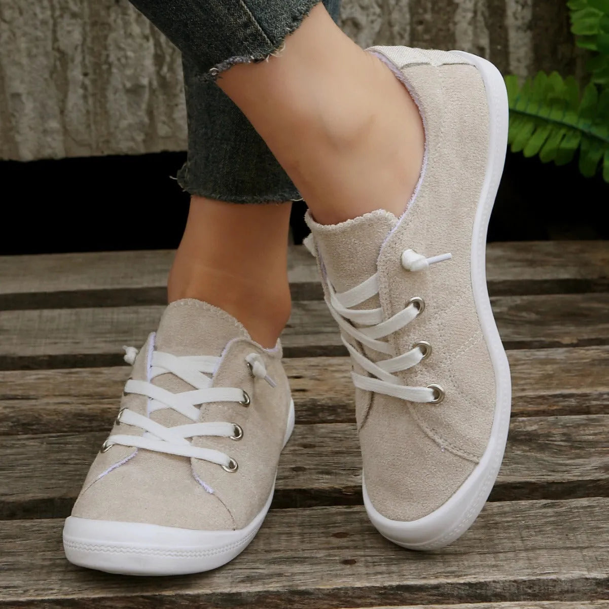 Women's creamy white casual low-top sneaker with soft fabric upper and rubber sole.