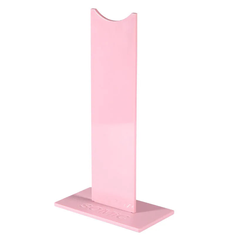 Pink detachable headphone stand with non-slip silicone base displaying over-ear headphones