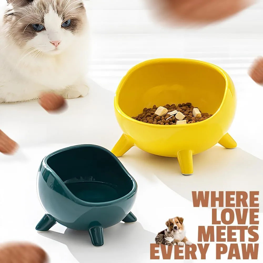 Green ceramic cat food bowl with four legs, wide mouth, and rounded arc shape on a light floor