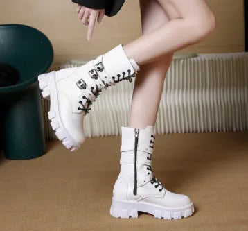 Women's black mid-calf buckle boots with side zipper and round toe on wooden floor