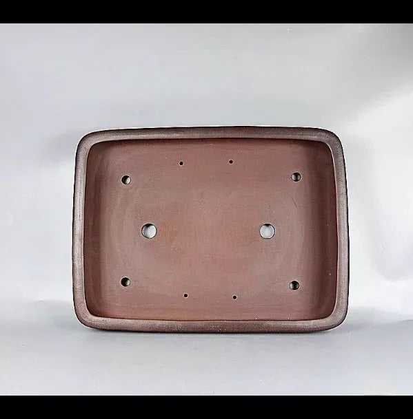Handmade antique rectangular purple clay flower pot for plants on a tabletop.