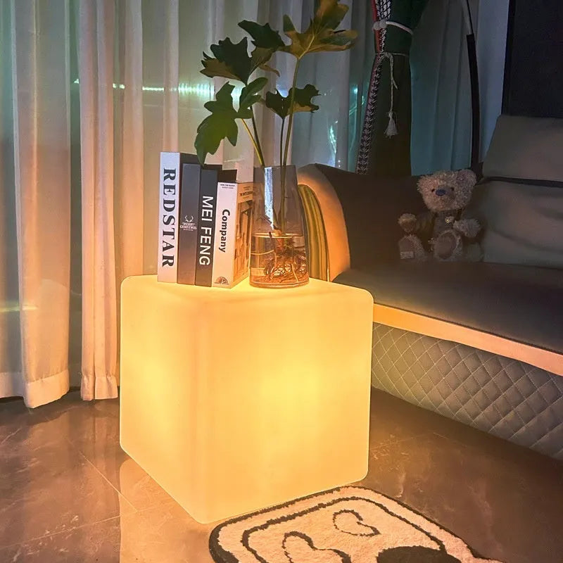 Modern LED illuminated cube stool in outdoor garden setting showing waterproof construction and integrated lighting