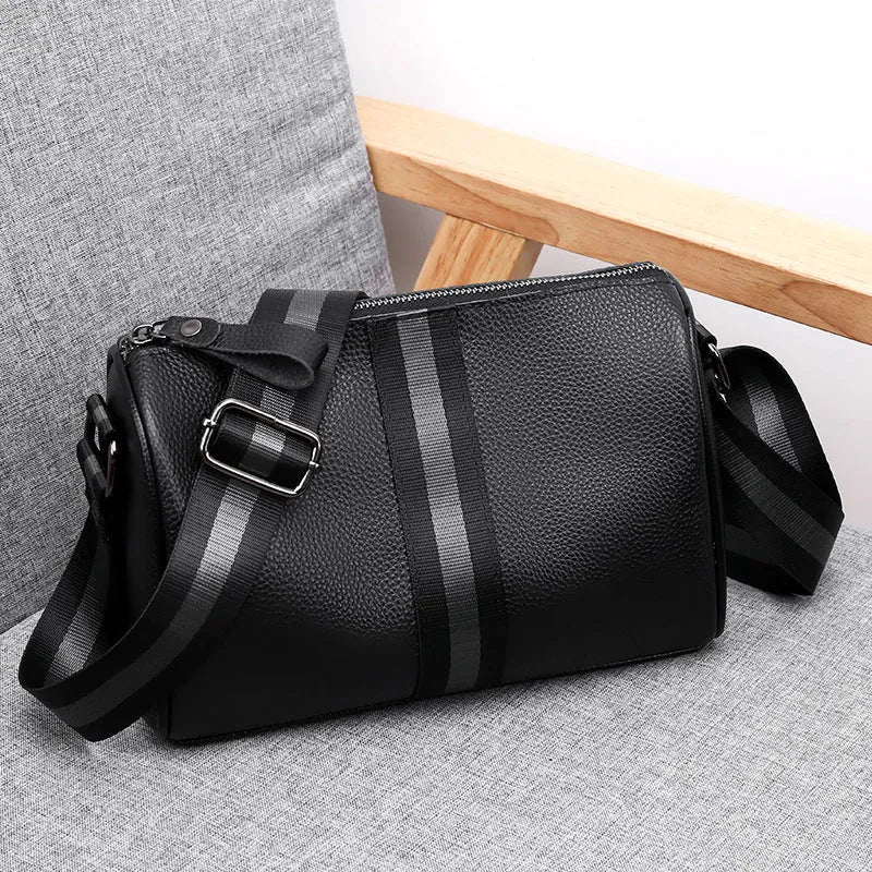 Black genuine leather crossbody bag with one shoulder strap showing interior polyester lining