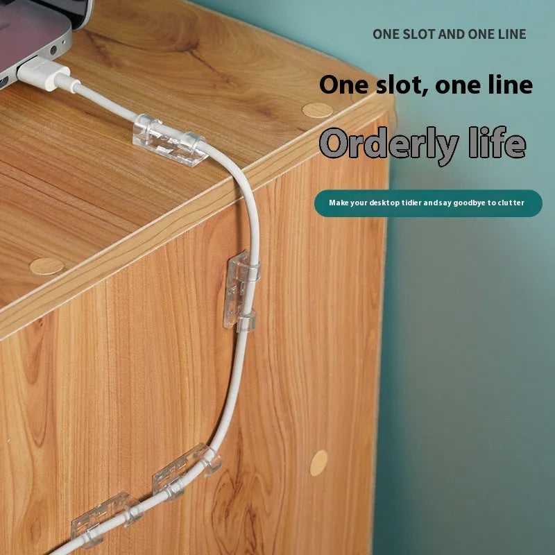 Transparent plastic self-adhesive wire holder routing snap clip on a desk surface with a white cable inserted