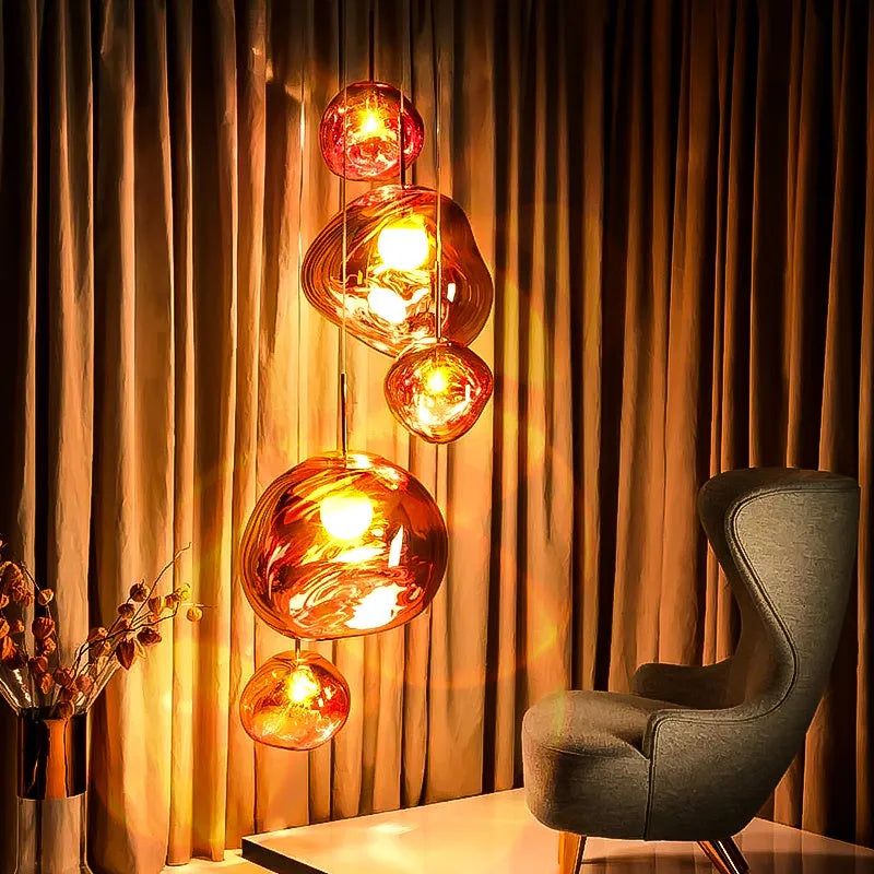 Nordic post-modern lava lamp chandelier with glass body and metallic finish in bedroom setting