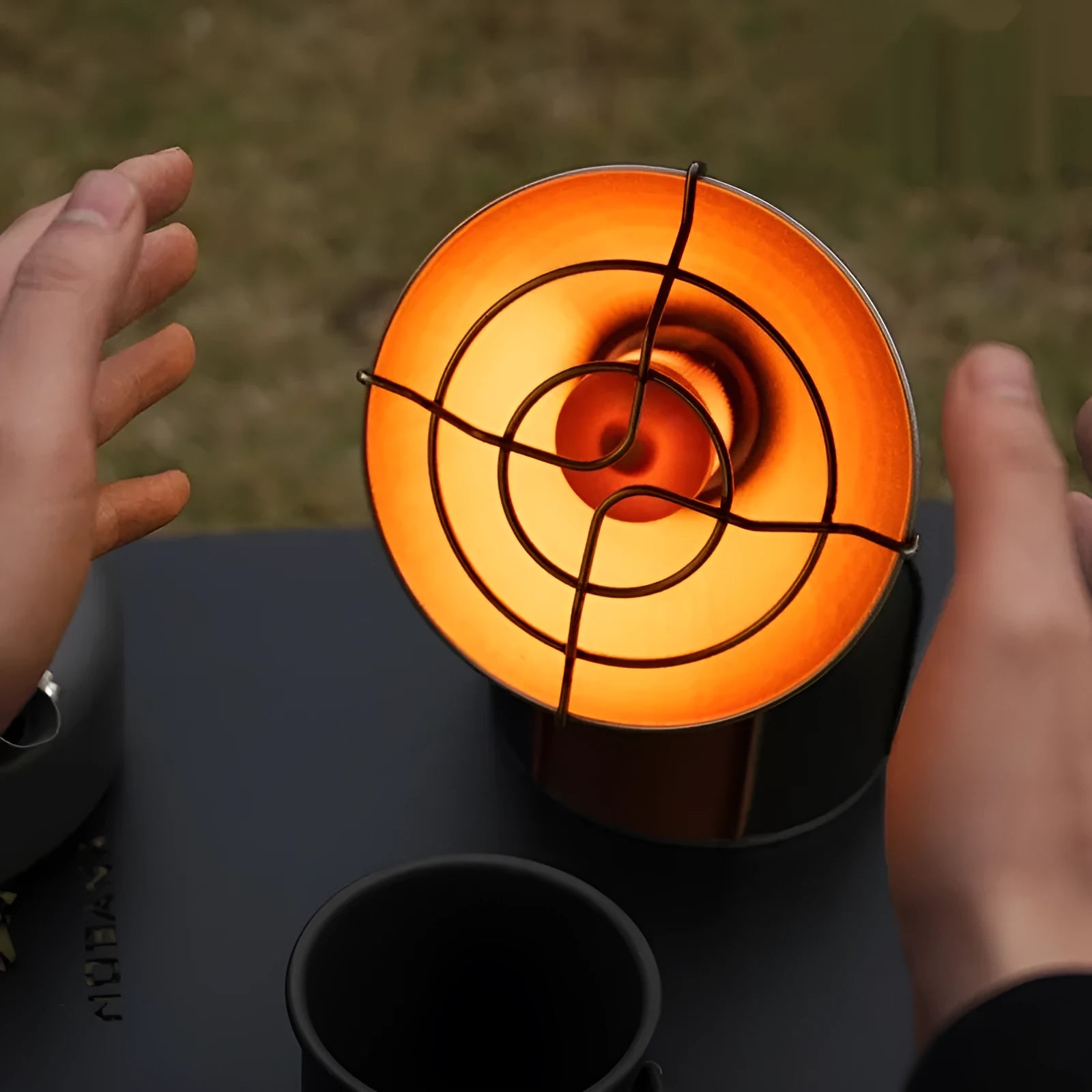 Black and orange portable outdoor heating stove with automatic press ignition for camping