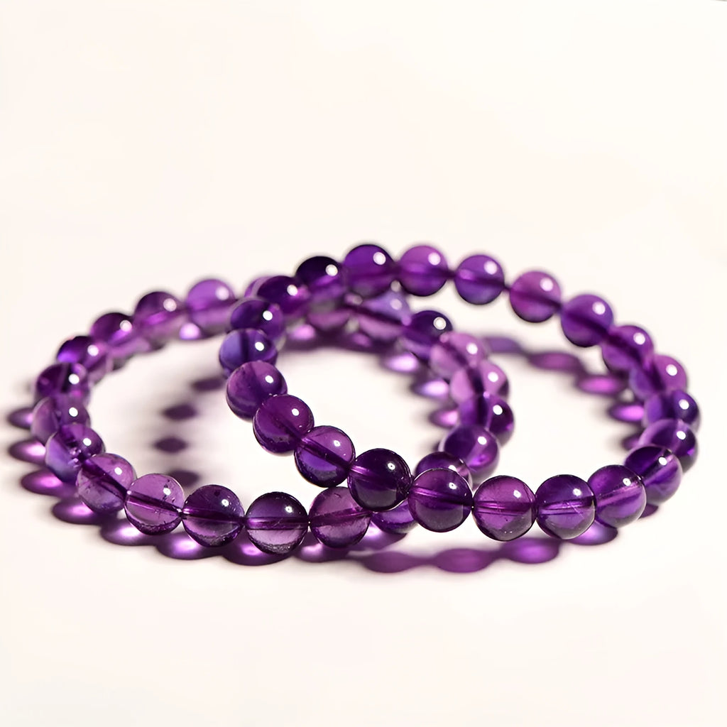 Natural Uruguayan amethyst crystal bracelet with round polished beads on a black stretch cord.