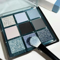 MUGELEEN nine-colour eye shadow palette showing earth tones with blue smoked variations