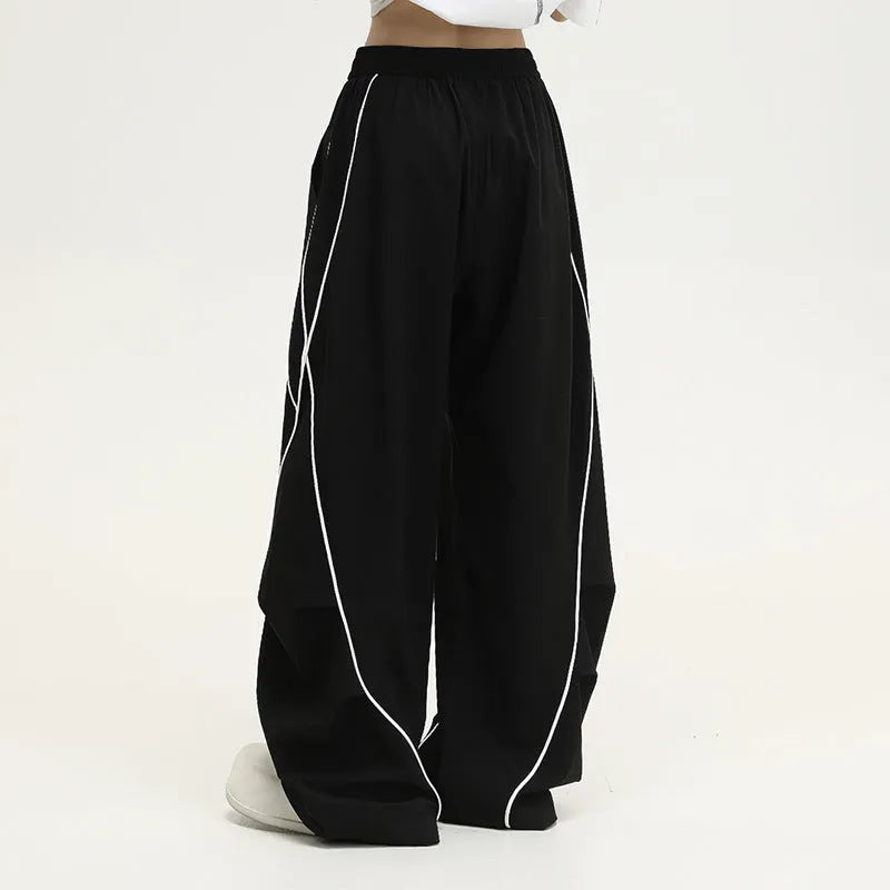 Black pleated hip hop sports pants with stripe pattern showing wide-leg design and mid-waist fit