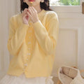 Women's solid colour cardigan with a bow and pearl buttons, in a light yellow acrylic knit.