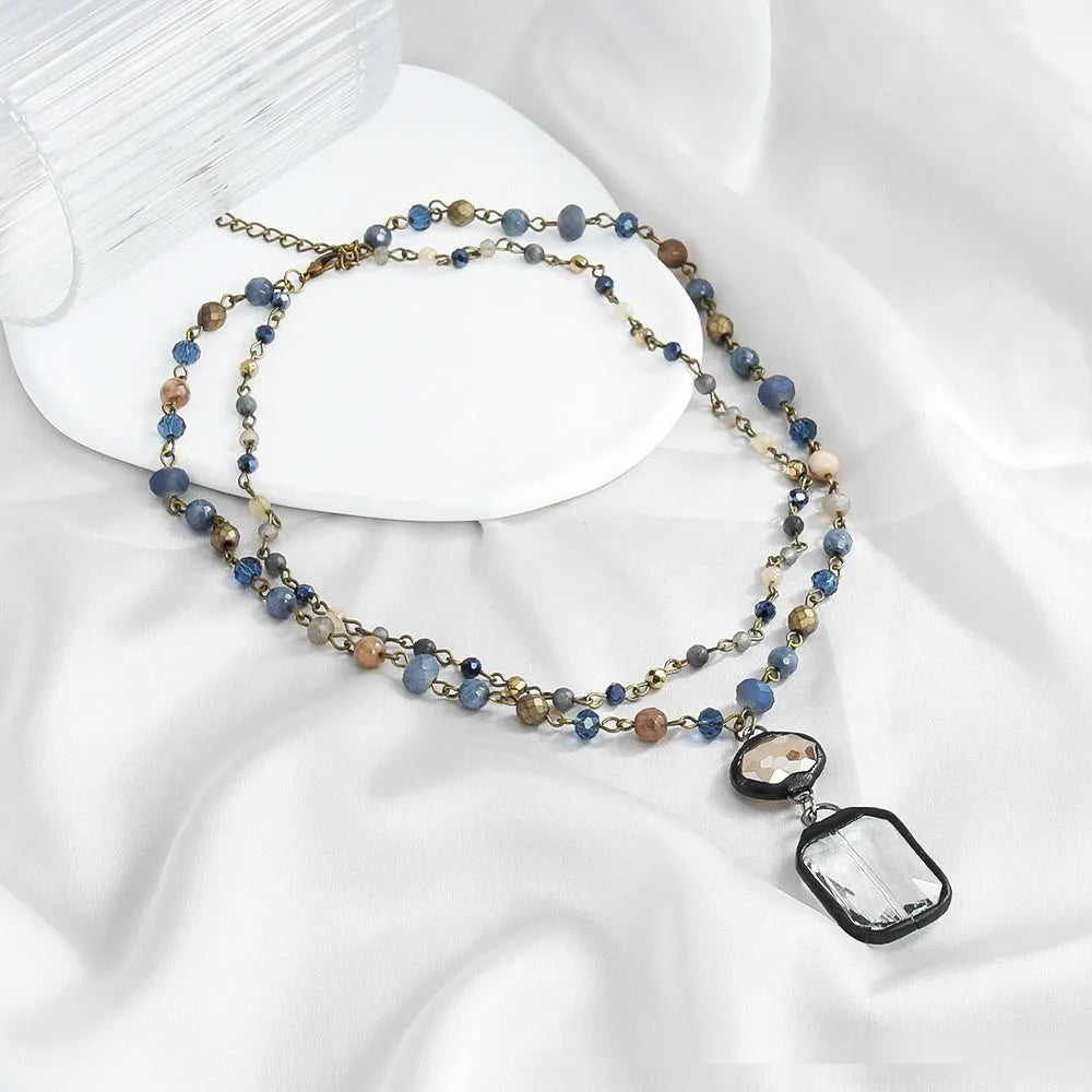 Two-layer tribal style necklace with glass and stone pendants on adjustable chain