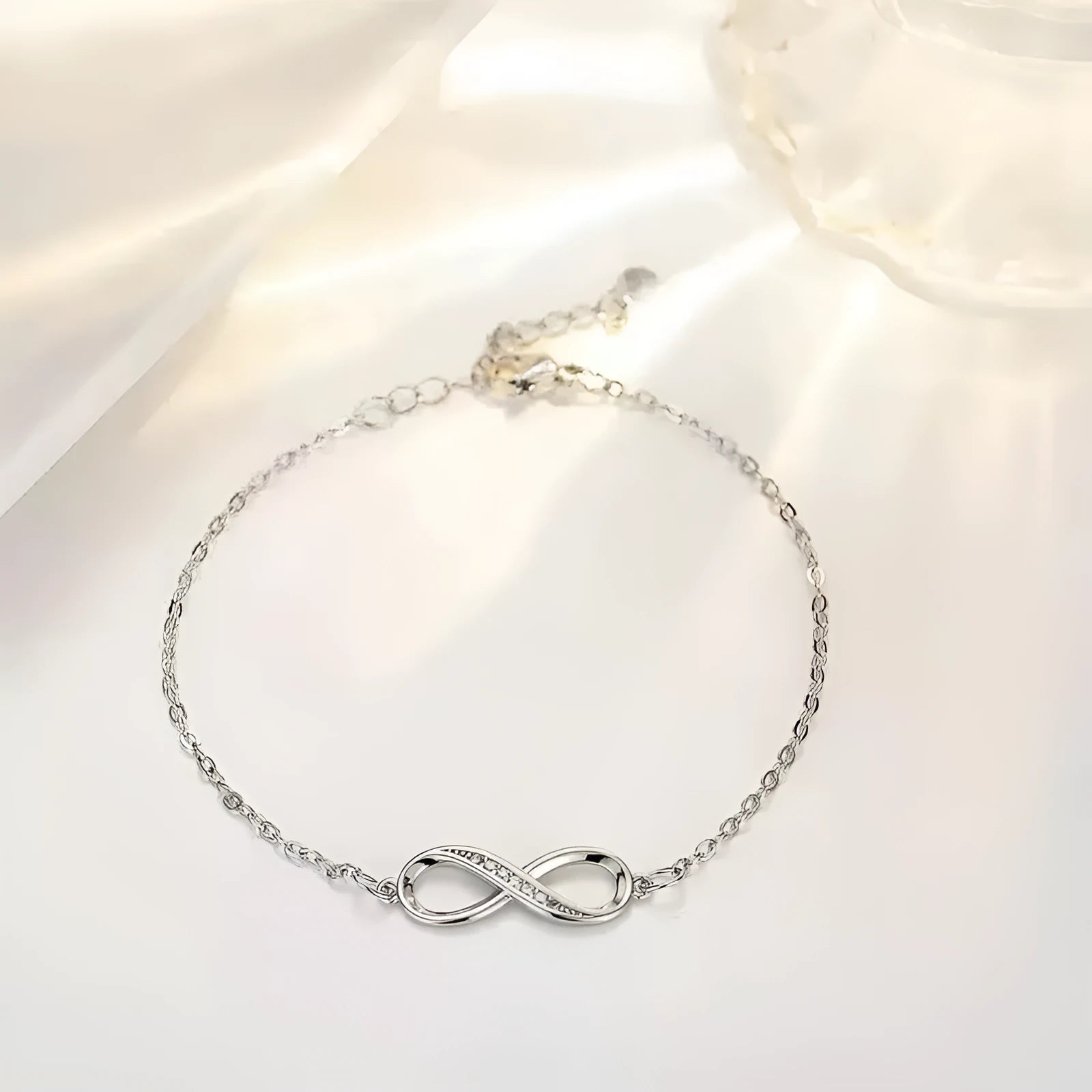 Silver copper Mobius strip diamond ring push-pull bracelet with lucky cat charm on display.