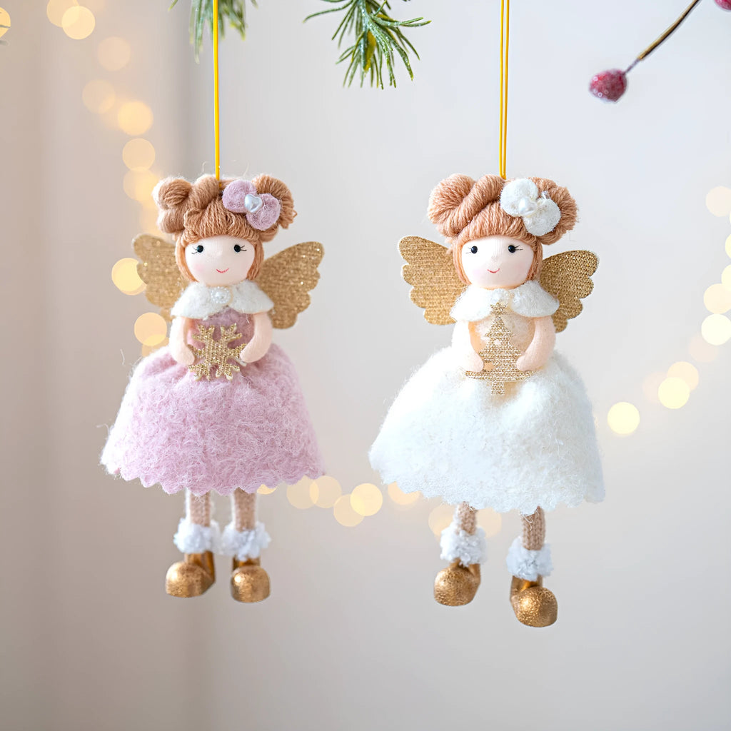 Soft pink cloth Christmas pendant ornament shaped like angel wings on a green branch.