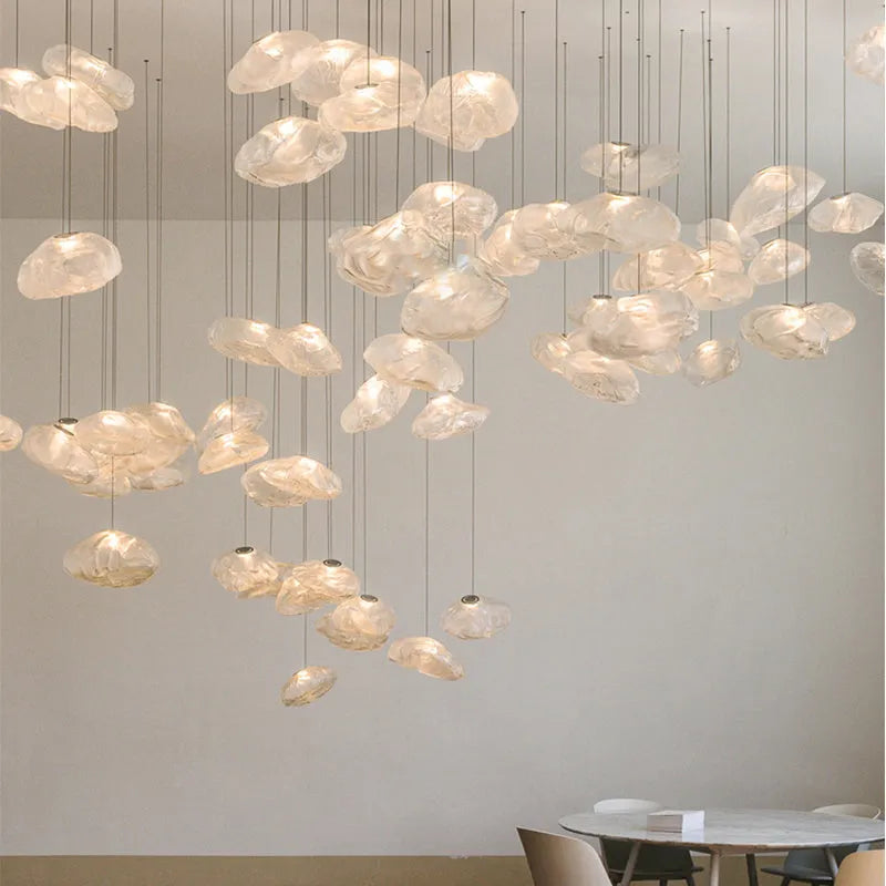 Modern decorative chandelier with glass shade and fabric design, available in amber, clear, or smoke grey.