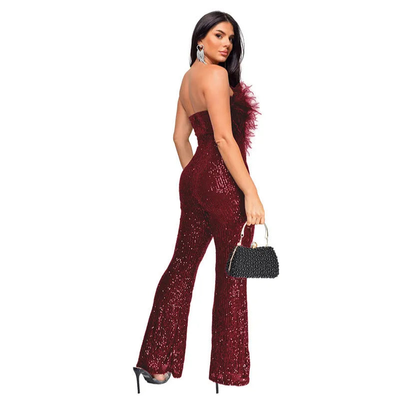 Women's black sleeveless backless jumpsuit with sequin detailing on top and flared legs.