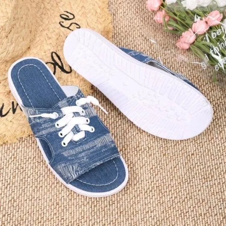 Blue women's Roman style canvas slippers with a flat rubber sole on a white background.