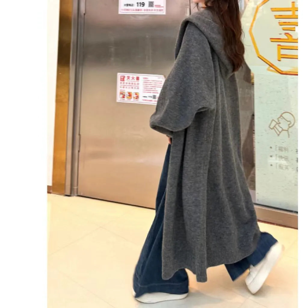 Long brown hooded knitted cardigan for women in a loose, below-the-knee fit.